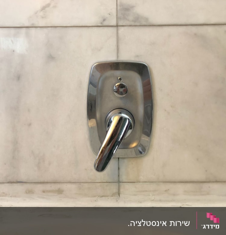 ידית ברז כרום על קיר שיש